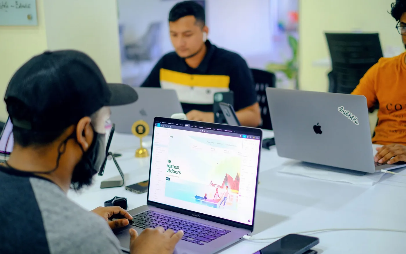 Professional team collaborating at laptop computers in an office